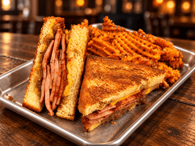 Grilled sandwich with waffle fries.